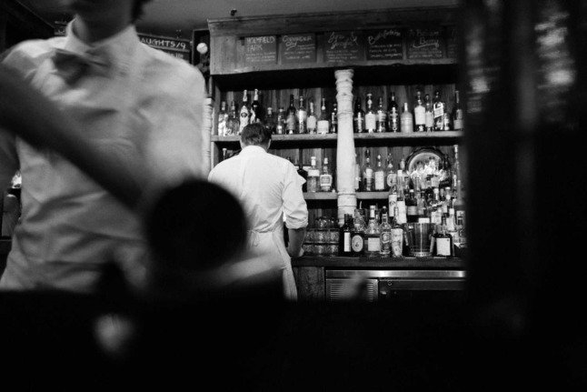 Des serveurs préparent des boissons dans un bar. Photo en noir et blanc. Photo : Pixabay