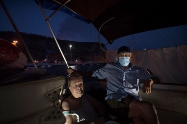 Margaretha Straates et Luis, 80 et 90 ans, attendent sur leur bateau où ils se sont installés après avoir fui leur maison suite à l'éruption du volcan Cumbre Vieja il y a deux semaines, dans le port de Tazacorte, sur l'île canarienne de La Palma, le 3 octobre 2021. - Un nouveau flux de lave très liquide a émergé du volcan en éruption dans les îles Canaries en Espagne le 1er octobre, ont déclaré les autorités, alors qu'un énorme plateau magmatique continue de se construire sur l'océan Atlantique. (Photo de JORGE GUERRERO / AFP)