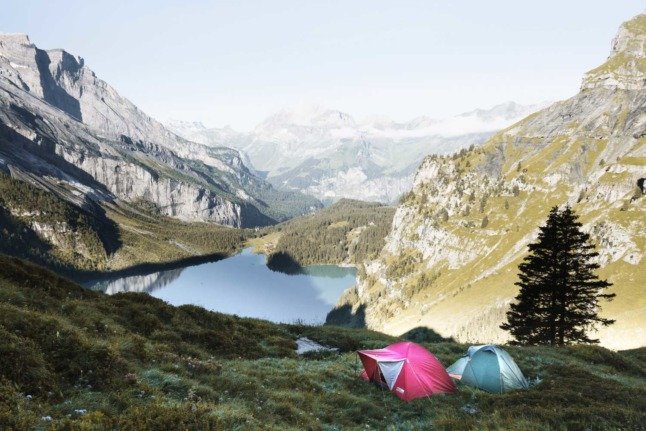 Des personnes campant au-dessus du lac Oeschinen, à Kandersteg, en Suisse.