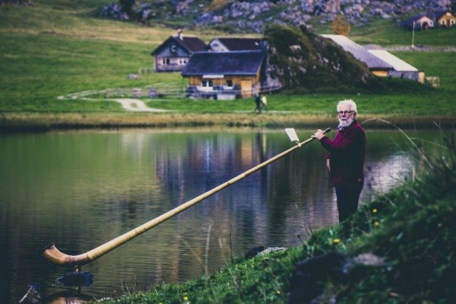 Un homme avec une pipe inhabituellement grande sur un lac en Suisse. Image : Pexels.