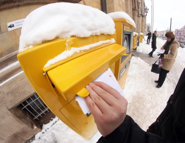 Un homme poste une lettre dans la neige à Magdebourg.