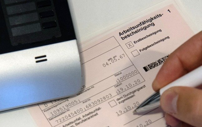 Un médecin signe une fiche d'incapacité de travail en Allemagne. 