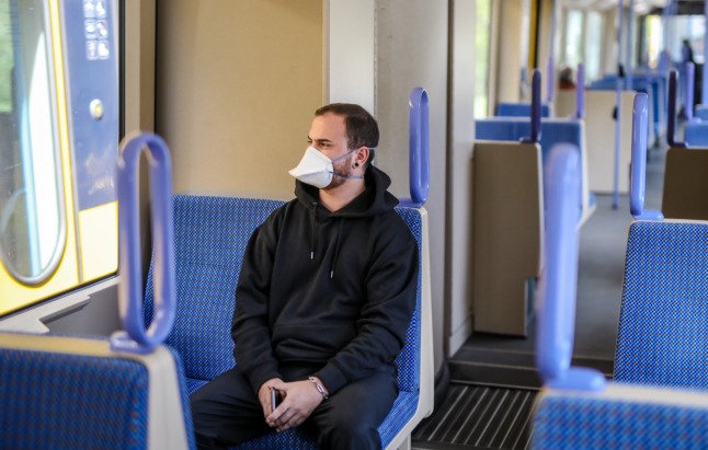 Un homme porte un masque médical dans un train local à Stuttgart.