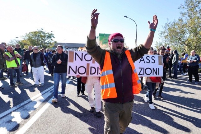 Des dockers et des travailleurs portuaires manifestent devant la porte 4 du port de Trieste le 15 octobre 2021 pour protester contre les nouvelles restrictions liées au coronavirus pour les travailleurs. 