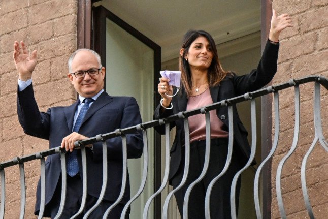 Gualtieri et la maire sortante de Rome Virginia Raggi saluent depuis un balcon lors d'une cérémonie de passation de pouvoir le 21 octobre 2021. 