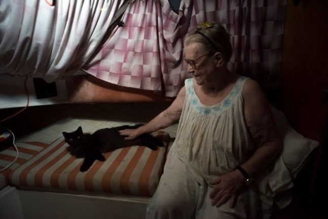 Margaretha Straates, 80 ans, est assise à côté de son chat sur le bateau où elle et son mari sont logés. Photo : Jorge Guerrero/AFP