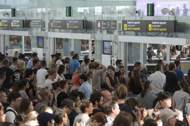 Les passagers font la queue pour passer le contrôle de sécurité à l'aéroport El Prat de Barcelone. 