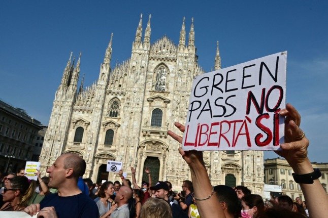 Des manifestants prennent part à une manifestation contre le passeport vert sur la Piazza Duomo à Milan, le 24 juillet 2021. Sur la pancarte, on peut lire 