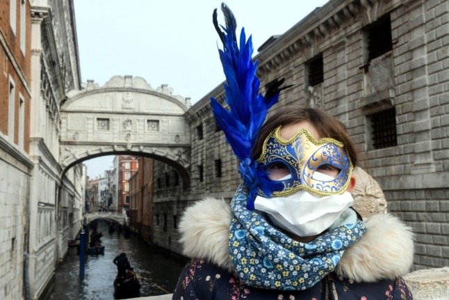 Un touriste porte un masque protecteur et un masque de carnaval à Venise le 24 février 2020, lorsque les festivités du carnaval auraient normalement lieu. 