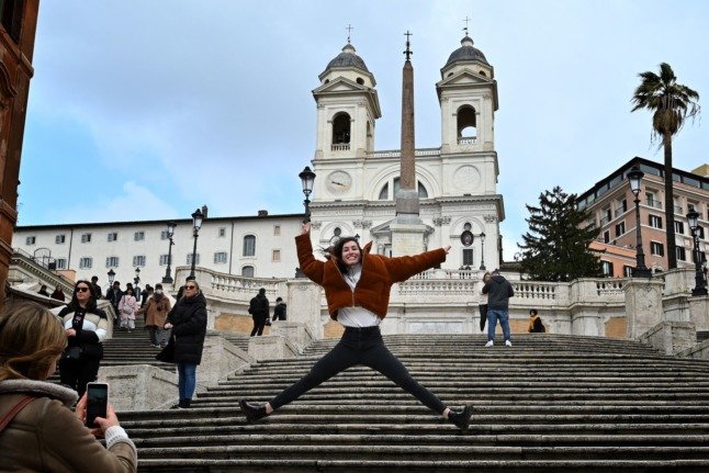 Un touriste pose pour une photo devant la place d'Espagne à Rome le 3 mars 2020