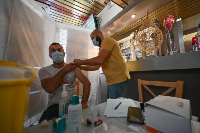Un homme se fait vacciner contre le Covid dans un restaurant