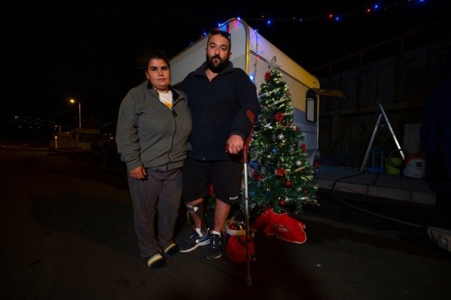 Jesica Díaz et Ricardo Pérez posent à côté d'un sapin de Noël installé devant leur caravane à Los Llanos de Aridane sur l'île canarienne de La Palma le 12 décembre 2021. Photo : PIERRE-PHILIPPE MARCOU/AFP
