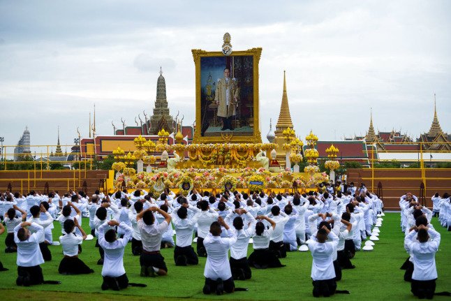Des personnes rendent hommage à une photo du défunt roi de Thaïlande Bhumibol Adulyadej lors du 4e anniversaire de sa mort en 2020. 