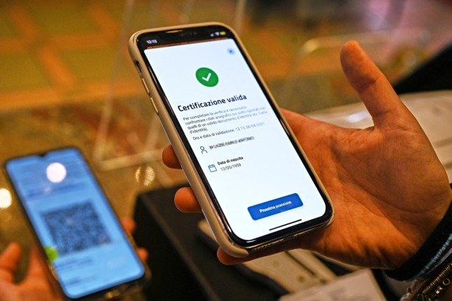 Le propriétaire d'un bar utilise l'application pour téléphone mobile VerifyC19 pour scanner le « pass vert » d'un client dans le centre de Rome. 