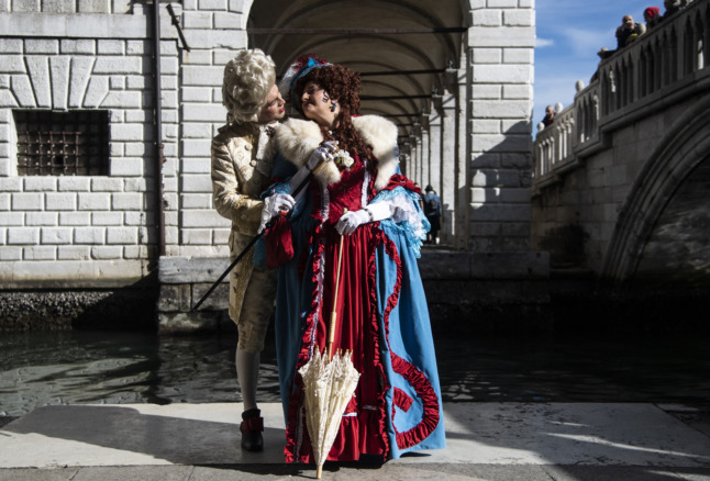 Un couple costumé pose sur la place Saint-Marc pendant le carnaval de Venise le 13 février 2022. 