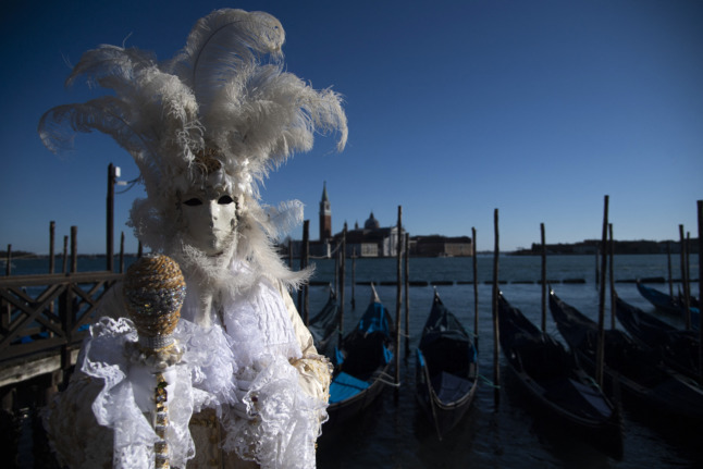 Un personnage masqué pose sur la place Saint-Marc pendant le carnaval de Venise le 12 février 2022. 