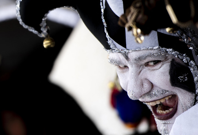 Un fêtard masqué portant un costume de carnaval traditionnel pose sur la place Saint-Marc pendant le carnaval de Venise le 13 février 2022. 