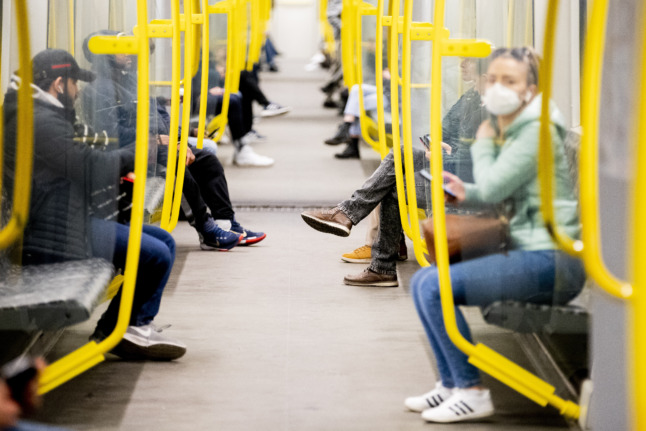 Les gens sont assis sur le U-Bahn de Berlin portant des masques