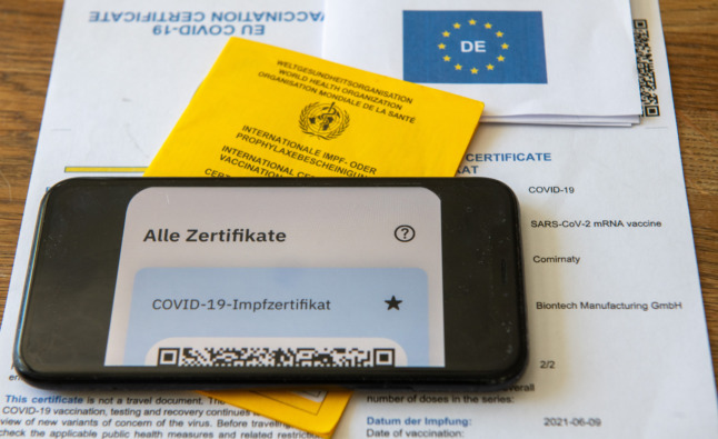 Un carnet de vaccination, un certificat de vaccination UE et un smartphone 