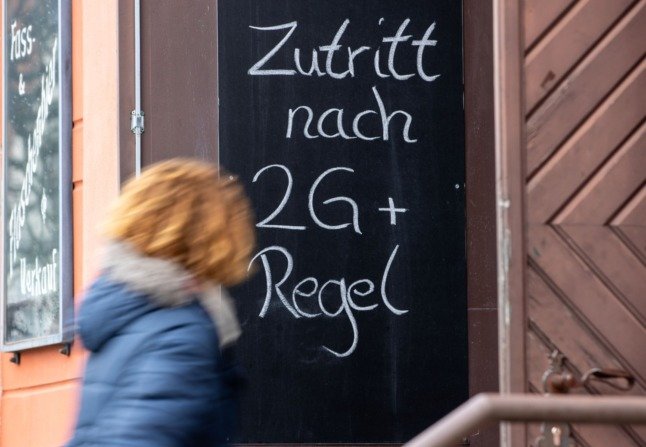 Une femme passe devant un panneau 2G-plus dans un restaurant de Griefswald.