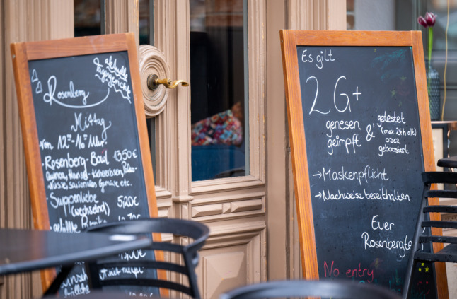 Un panneau indiquant un café à Potsdam, dans le Brandebourg, indique que l'entrée est réservée aux personnes vaccinées ou récupérées avec un test Covid ou une injection de rappel (2G-plus).