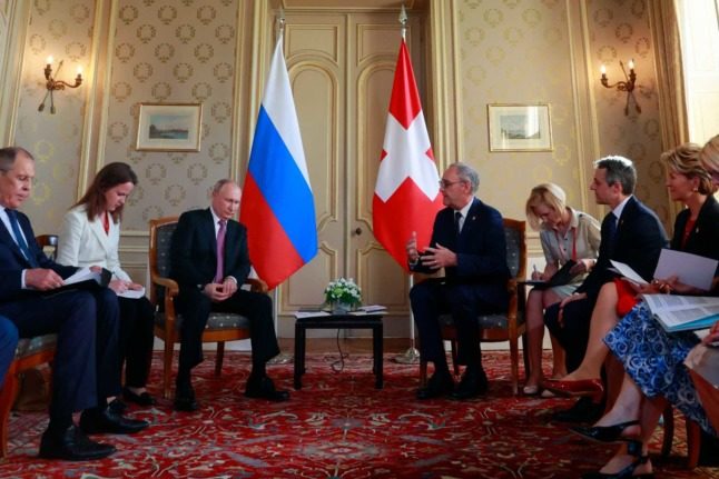 Le dirigeant russe Vladimir Poutine et l'ancien président Guy Parmelin. DENIS BALIBOUSE / POOL / AFP