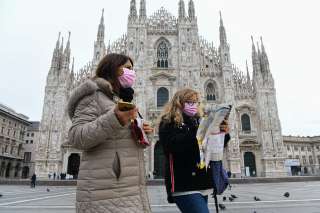 Les touristes consultent une carte à l'extérieur du Duomo de Milan. L'Italie a récemment assoupli ses restrictions Covid pour les visiteurs boostés. 