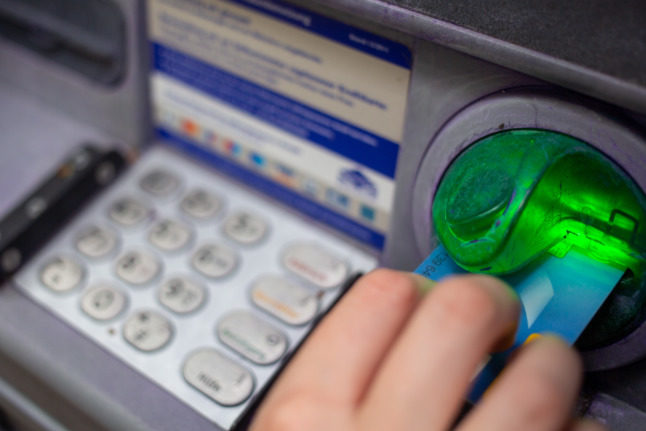 Un client retire de l'argent à un distributeur automatique en Allemagne.