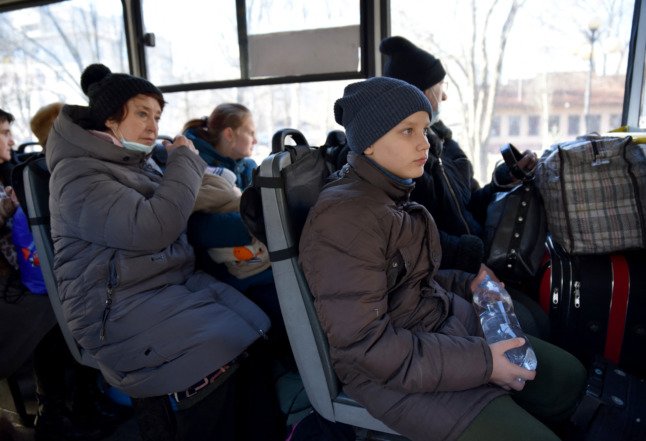 Des personnes sont assises dans un bus pour leur évacuation à Donetsk le 19 février 2022. 