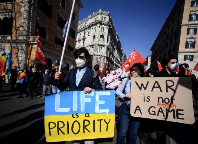 Des manifestants à Rome tiennent des pancartes protestant contre l'invasion de l'Ukraine par la Russie.