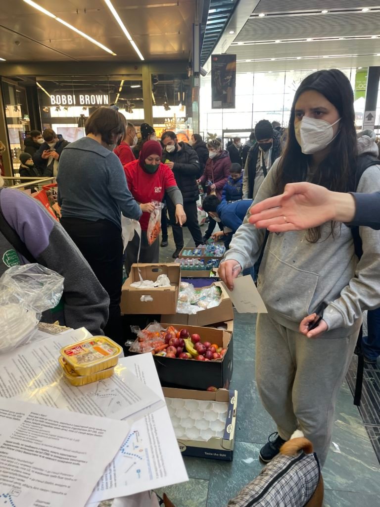 Une femme demande de l'aide au point d'information Caritas.