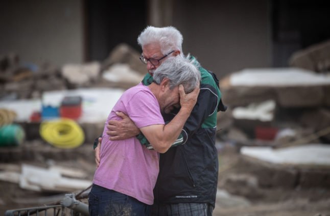 Les frères Bernd et Gerd Gasper se serrent l'un contre l'autre devant la maison de leurs parents endommagée par les inondations à Altenahr-Altenstadt, quelques jours après la catastrophe.