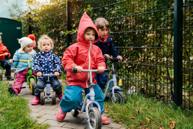 Des enfants font du tricycle dans un jardin d'enfants allemand. 