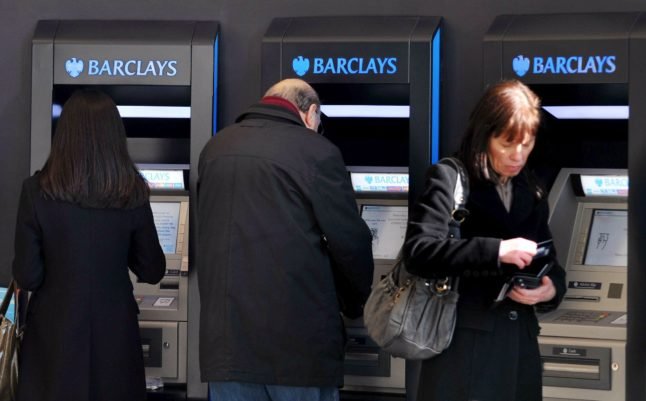 Des photos d'archives montrent des clients utilisant des distributeurs automatiques de billets Barclay à Londres.