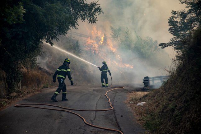 Des pompiers tentent d'éteindre un incendie près de la ville de Massarosa, dans le centre de l'Italie, le 20 juillet 2022.