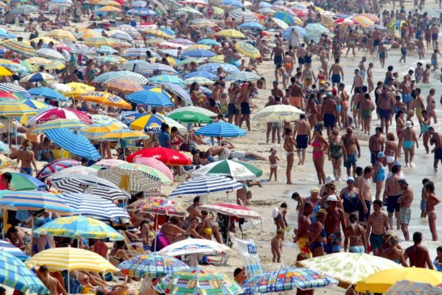 Des milliers de personnes sur la plage en Espagne avec des parasols