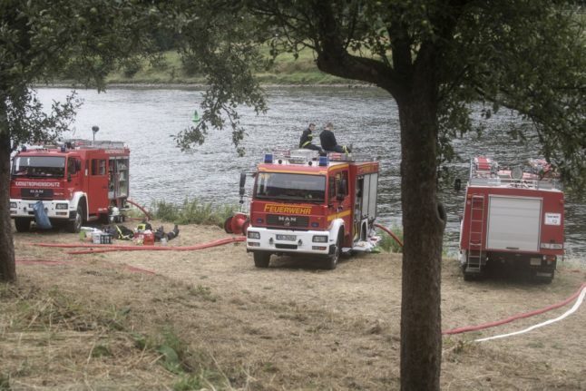 Des pompiers se reposent pendant que leurs moteurs font le plein d'eau.