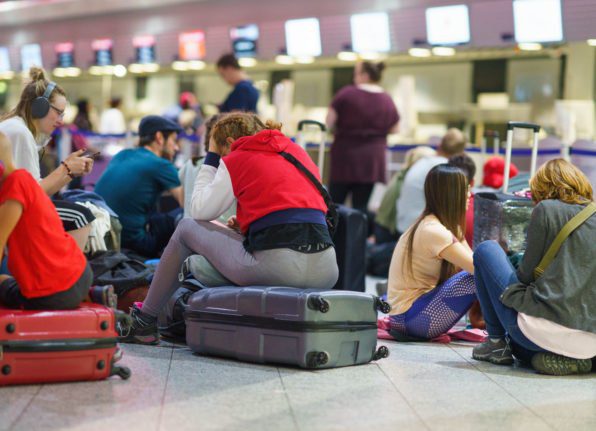 Des passagers attendent tôt le matin à l'aéroport de Francfort pendant la grève.