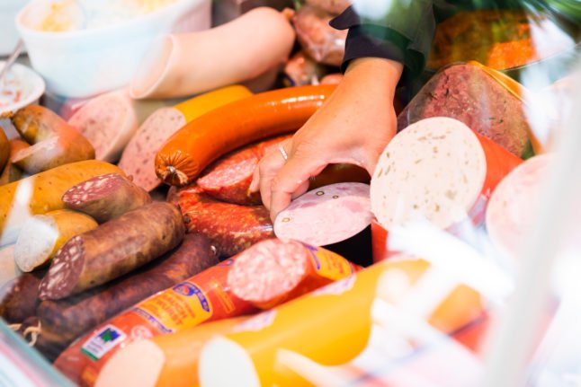 Une femme vend différents types de saucisses sur un marché de Berlin-Schöneberg en mai. 