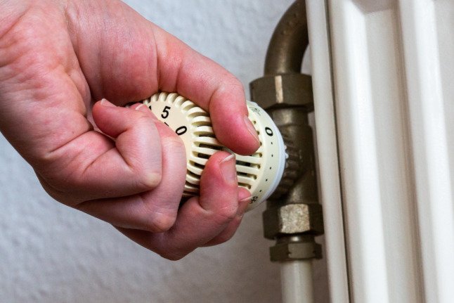 Une personne changeant le réglage de chauffage sur un radiateur. La coalition s'est engagée à soutenir financièrement les personnes en Allemagne.