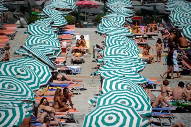 Des vacanciers prennent un bain de soleil sur une plage privée près de Santa Margherita Ligure, dans le sud de Gênes, le 11 août 2011. 