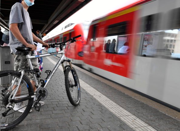 Un cycliste attend un train régional à Cologne