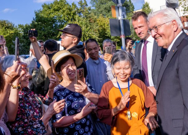 Le président allemand Frank-Walter Steinmeier est accueilli par des habitants après sa visite d'un temple bouddhiste-vietnamien dans le quartier de Lichtenhagen à Rostock.