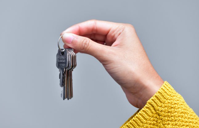 Une personne détient une paire de clés pour un appartement.