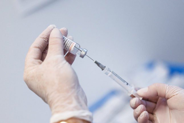 Une infirmière prépare une dose de vaccin Pfizer