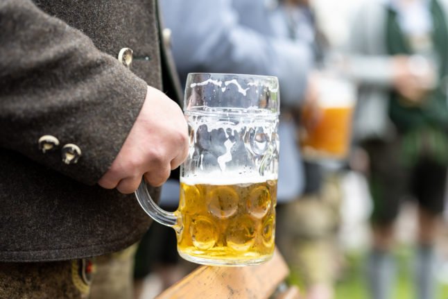 Un homme tient une bière à Perchting, en Bavière, lors des célébrations traditionnelles du 1er mai.