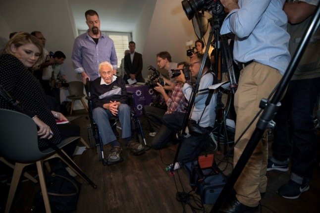 Le scientifique australien David Goodall (C) part en fauteuil roulant. Il n'a pas été autorisé à demander de l'aide pour mettre fin à ses jours en Australie, il a donc été contraint de se rendre en Suisse. (Photo par SEBASTIEN BOZON / AFP)