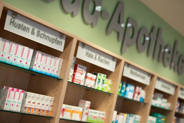Vue d'une étagère avec des médicaments contre la toux et le rhume dans une pharmacie.