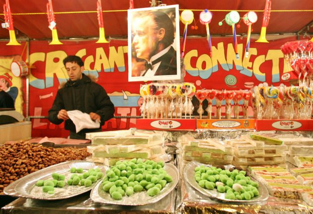 Un homme vend des friandises au massepain lors d'une fête à Catane, en Sicile.