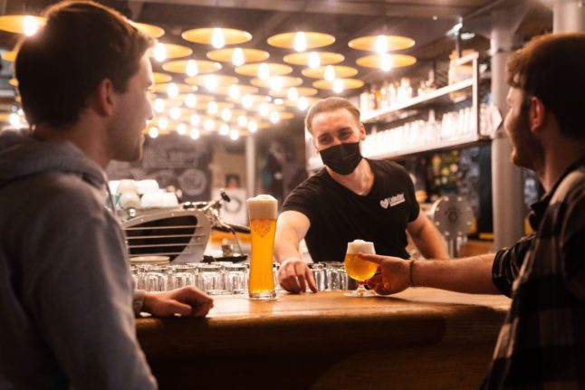Un barman sert des boissons à deux clients